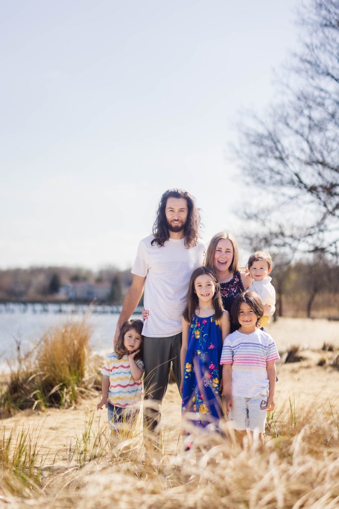 A family is posing for a Chesapeake Bay Foundation portrait on the beach.
