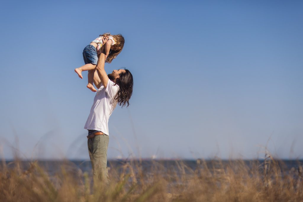 A family in Annapolis, Maryland, exuberantly holds their daughter up in the air.