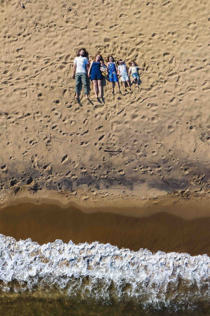 A family is enjoying a relaxing day at the beach, lounging on the sand.