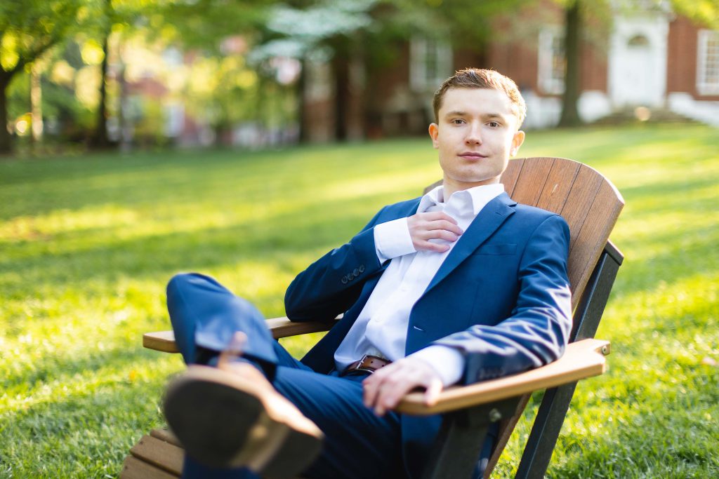 A High School Senior in a suit sitting on a lawn chair for their Graduation Portrait in Downtown Annapolis.