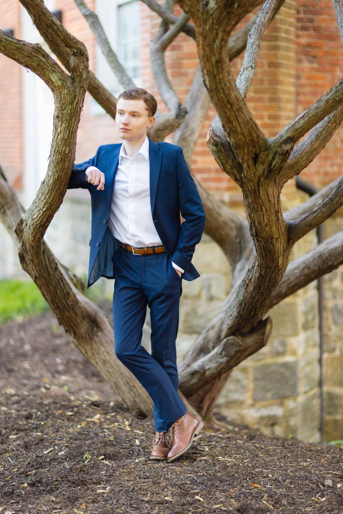 A High School Senior in a blue suit leaning against a tree in Downtown Annapolis.