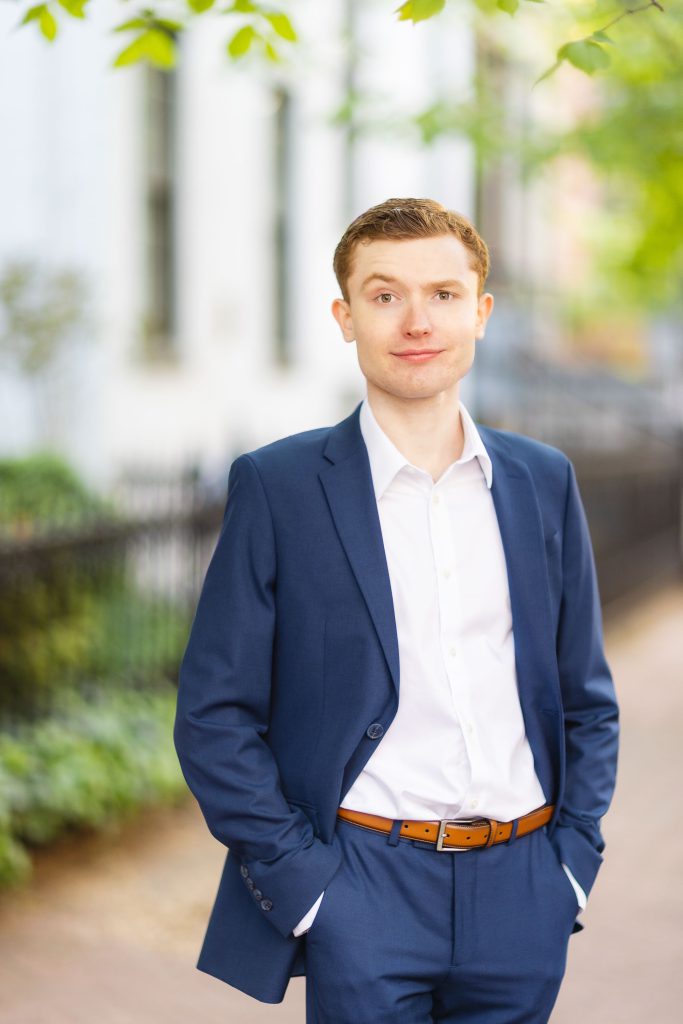 A High School Senior in a blue suit standing on a downtown Annapolis sidewalk for his Graduation Portrait.