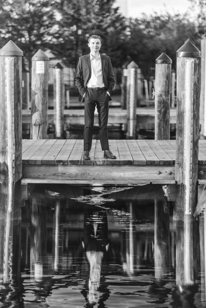 High School Senior portrait of a man standing on a dock in Downtown Annapolis.