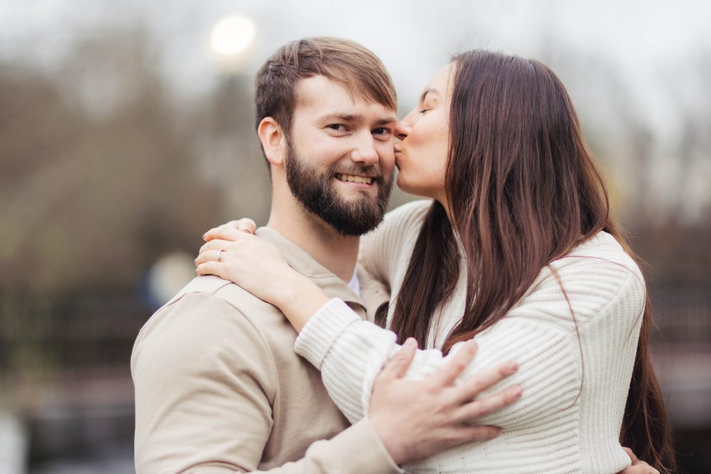 An engaged couple sharing a romantic kiss in Old Ellicott City, captured beautifully in a portrait for their engagement photo.