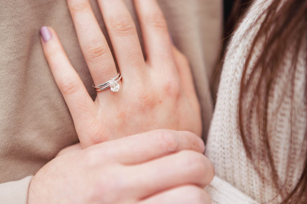 An engagement photo of a woman's hand adorned with a beautiful diamond engagement ring in Old Ellicott City.