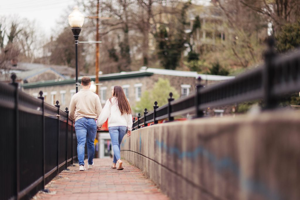 An engaged couple strolling through the charming brick walkways of Old Ellicott City, capturing romantic portraits for their engagement photos.