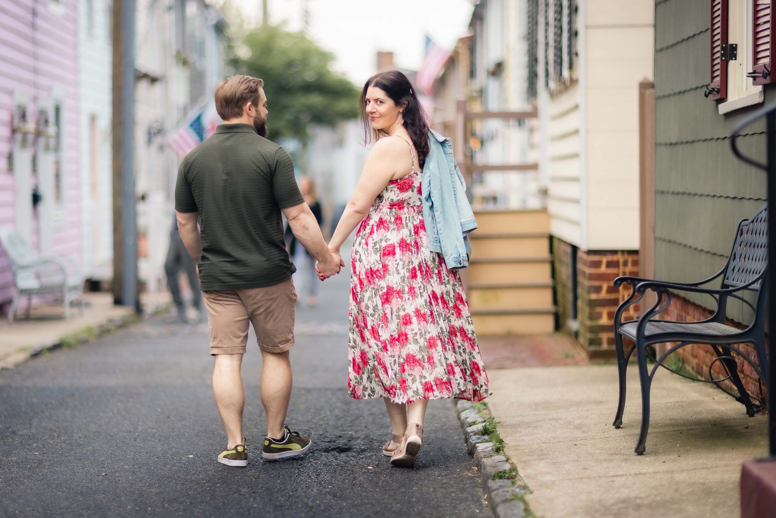 An engagement photoshoot of a couple walking down a downtown street in Annapolis, holding hands.