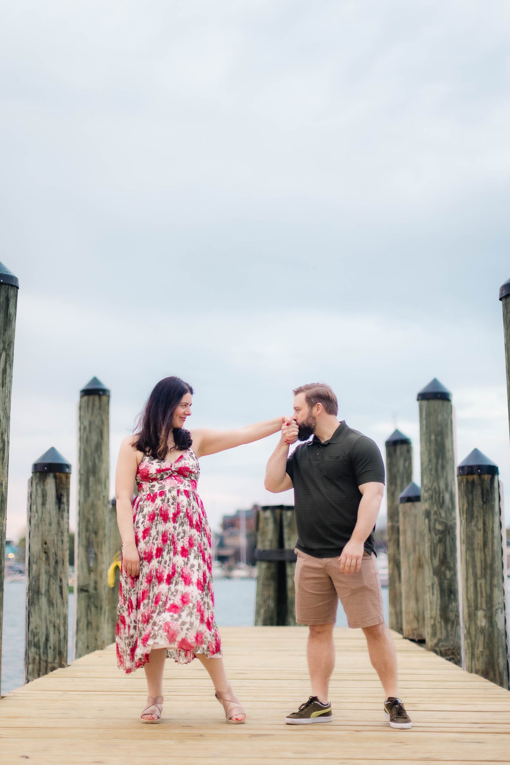 A portrait of an engaged couple standing on a dock in downtown Annapolis, capturing beautiful engagement photos.