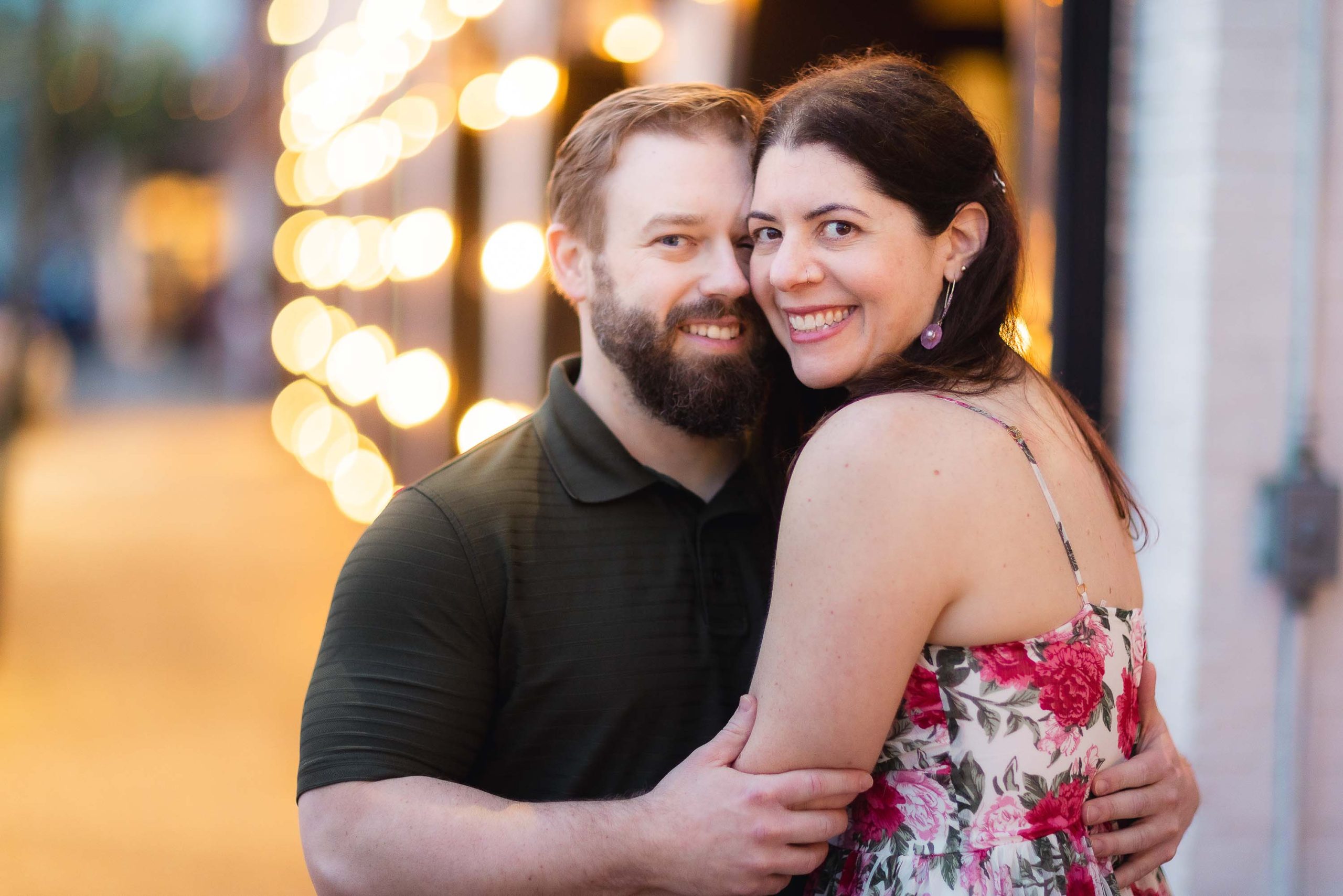 A portrait of an engaged couple embracing in front of a street light during their engagement photos session in downtown Annapolis.