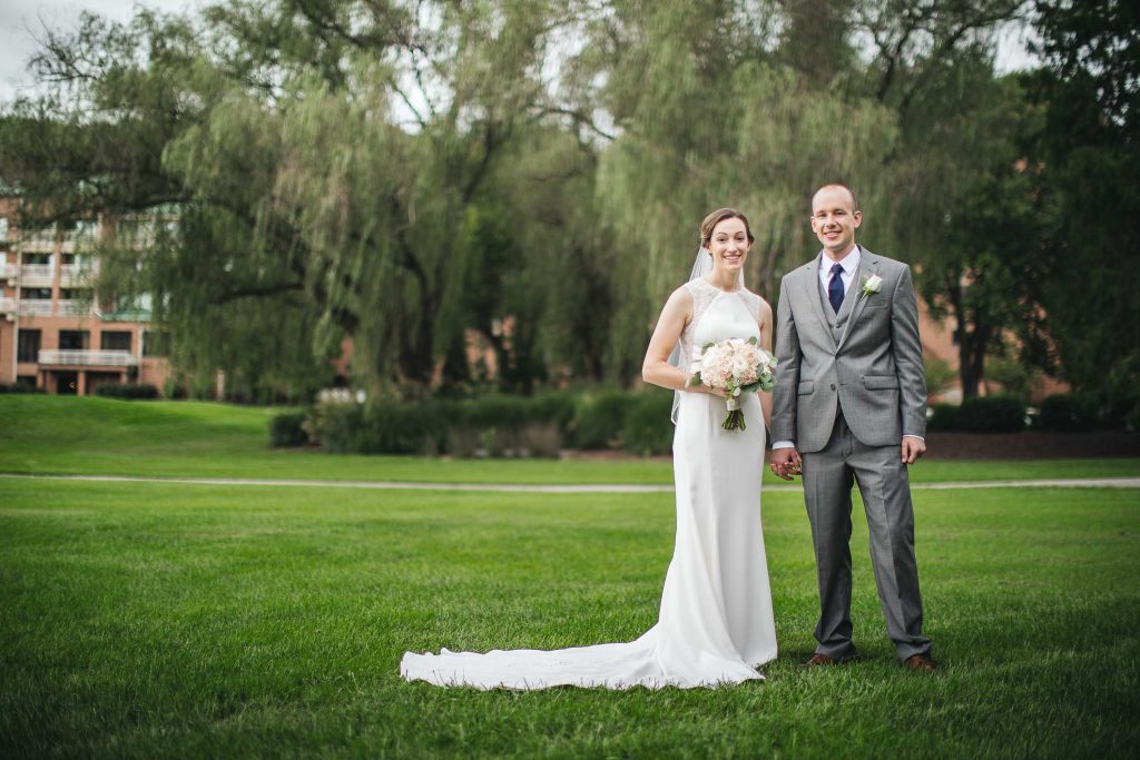 A bride and groom standing in a grassy field at Turf Valley Resort in Maryland near Ellicott City.