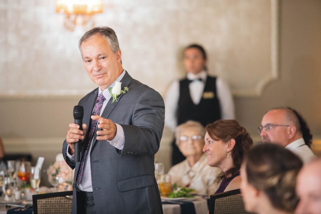 A man giving a speech at a wedding reception in Ellicott City.