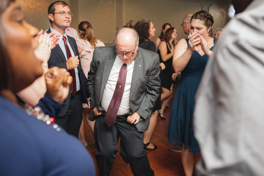 A man in a suit dancing at a wedding reception in Ellicott City, Maryland.