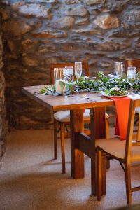 A stone wall serves as a backdrop for an event vendor at Vows & Vines.