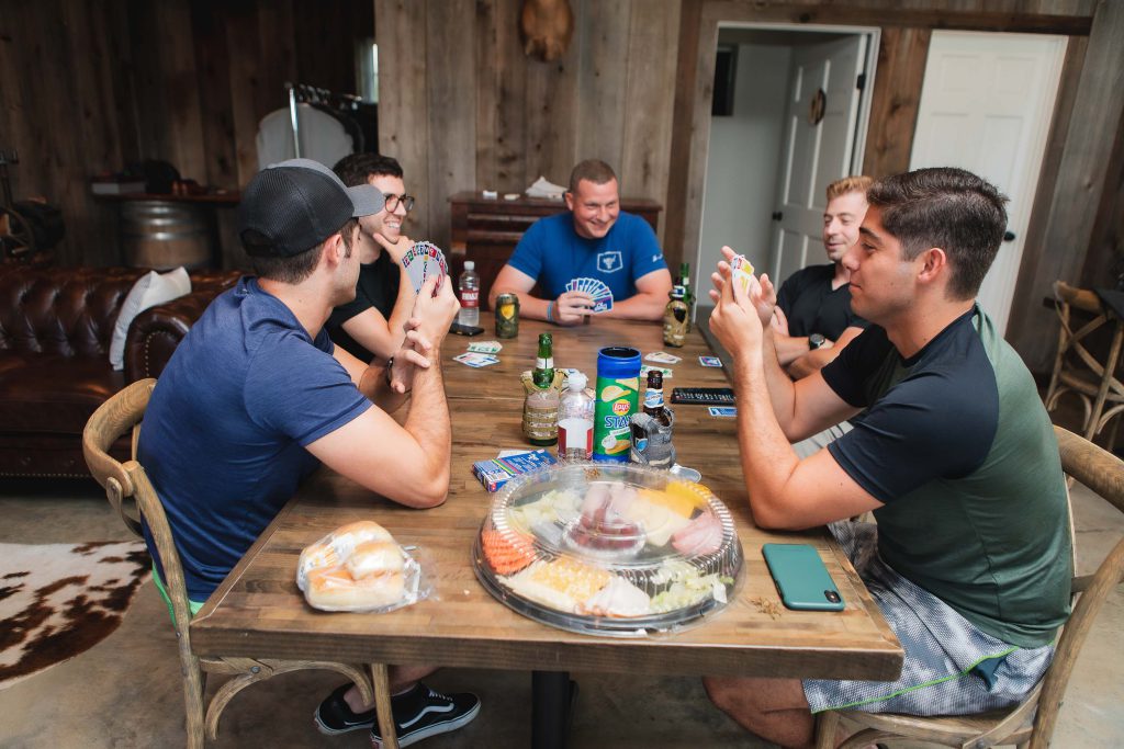 A candid group of men eating food at a wedding reception at Fleetwood Farm Winery.
