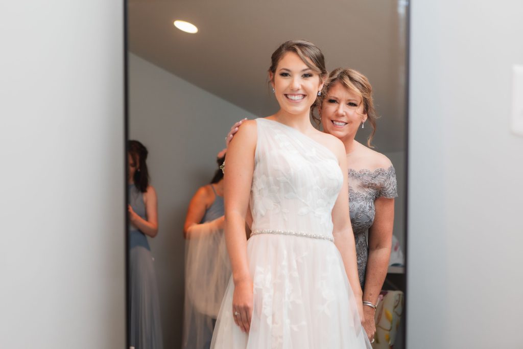 A wedding bride is getting ready in front of a mirror at Fleetwood Farm Winery.