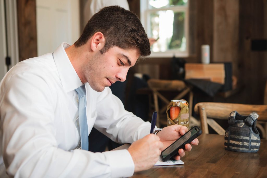A candid man seated at a table with a cell phone at Fleetwood Farm Winery.