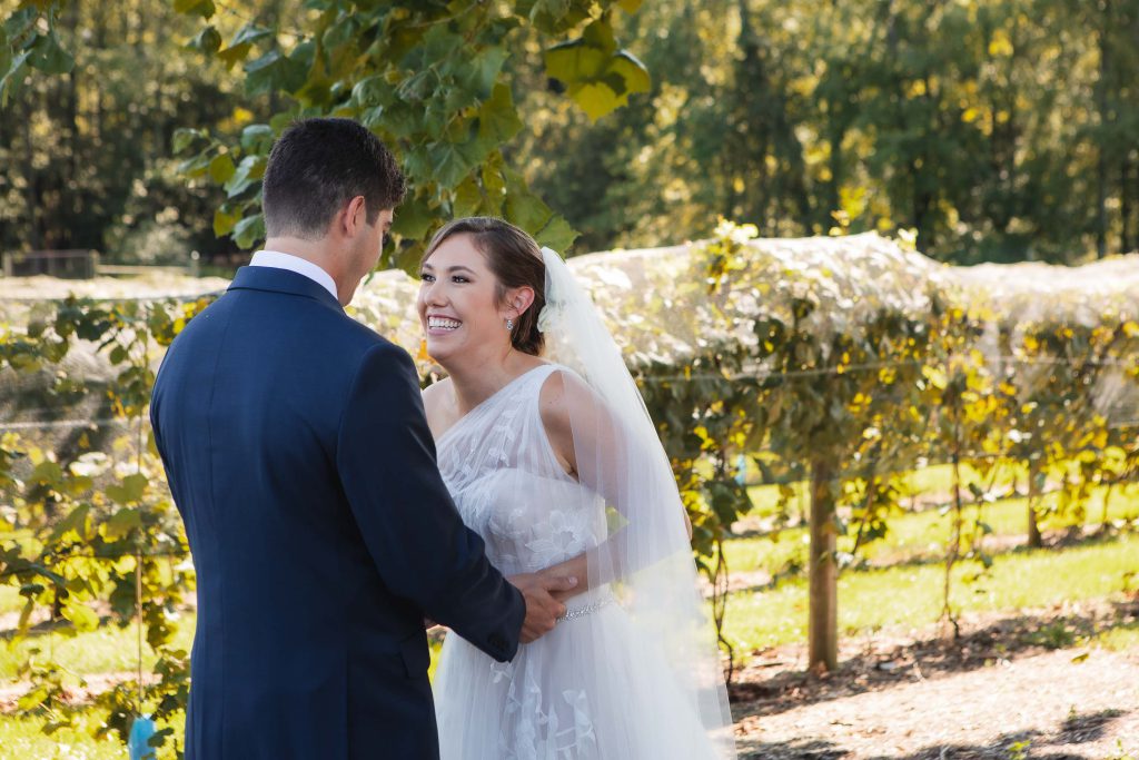 A wedding couple gracefully posing amidst the picturesque vineyard backdrop of Fleetwood Farm Winery.