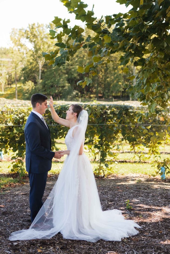 A candid wedding couple standing in the vineyard at Fleetwood Farm Winery.
