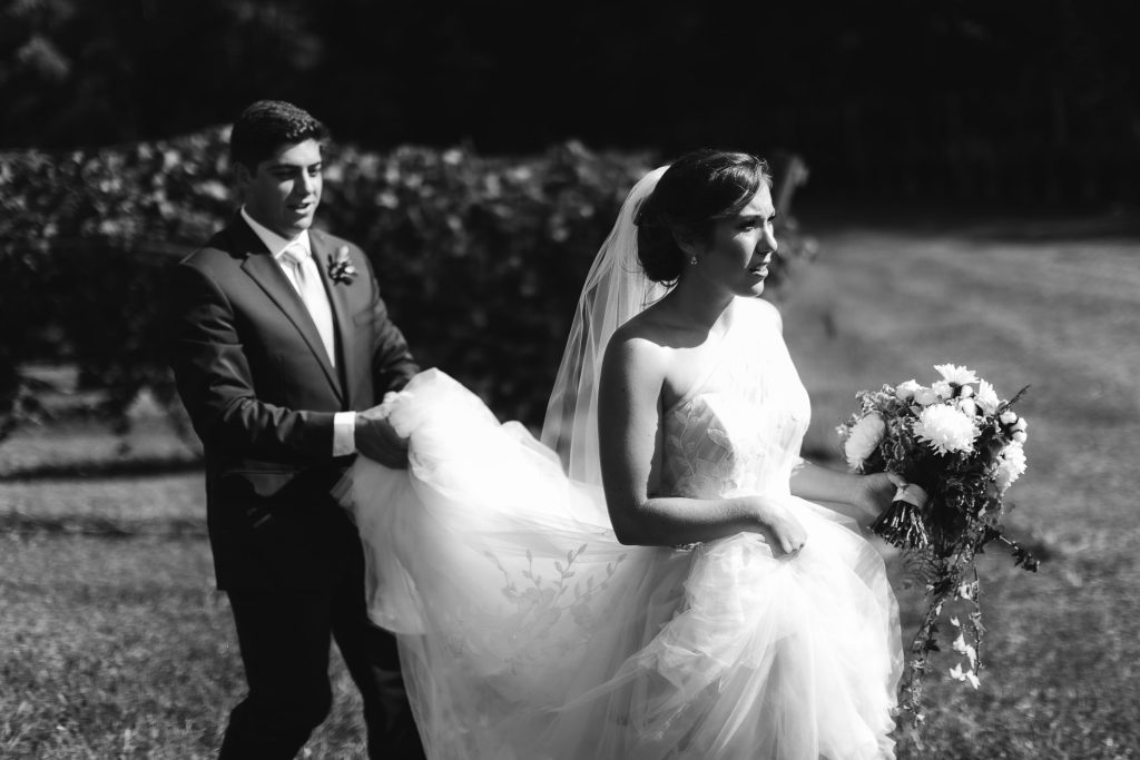 A candid bride and groom walking through Fleetwood Farm Winery on their wedding day.
