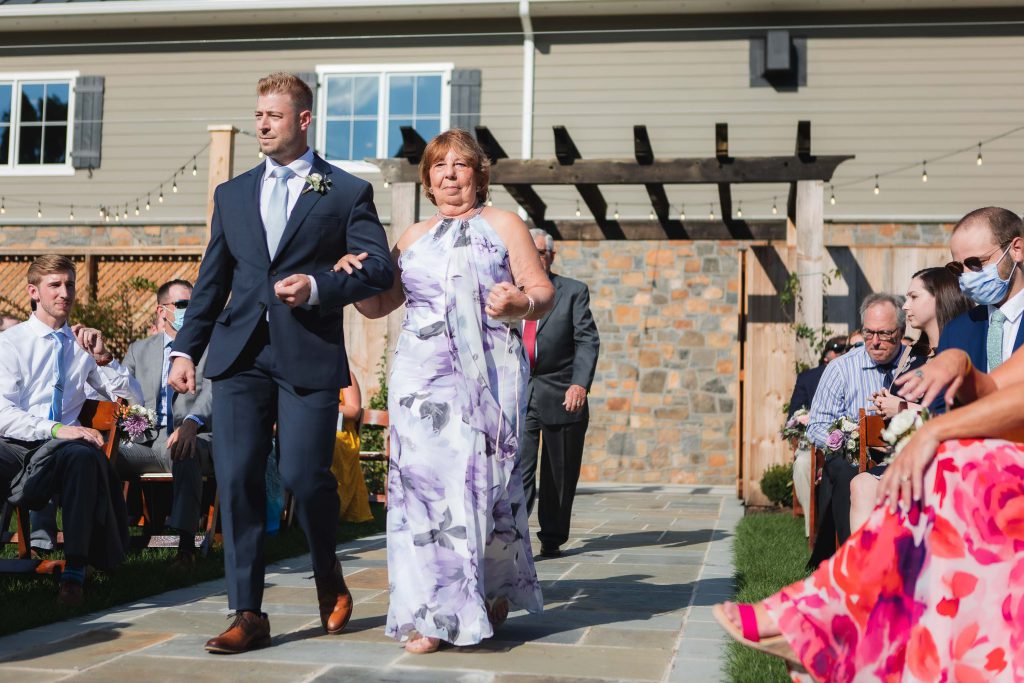 The wedding ceremony took place at Fleetwood Farm Winery, with the bride and groom gracefully walking down the aisle surrounded by nature's beauty.