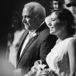 A black and white photo of a bride and her father walking down the aisle during their wedding ceremony at Fleetwood Farm Winery.