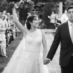 Black and white photo of bride and groom during their wedding ceremony at Fleetwood Farm Winery, walking down the aisle.