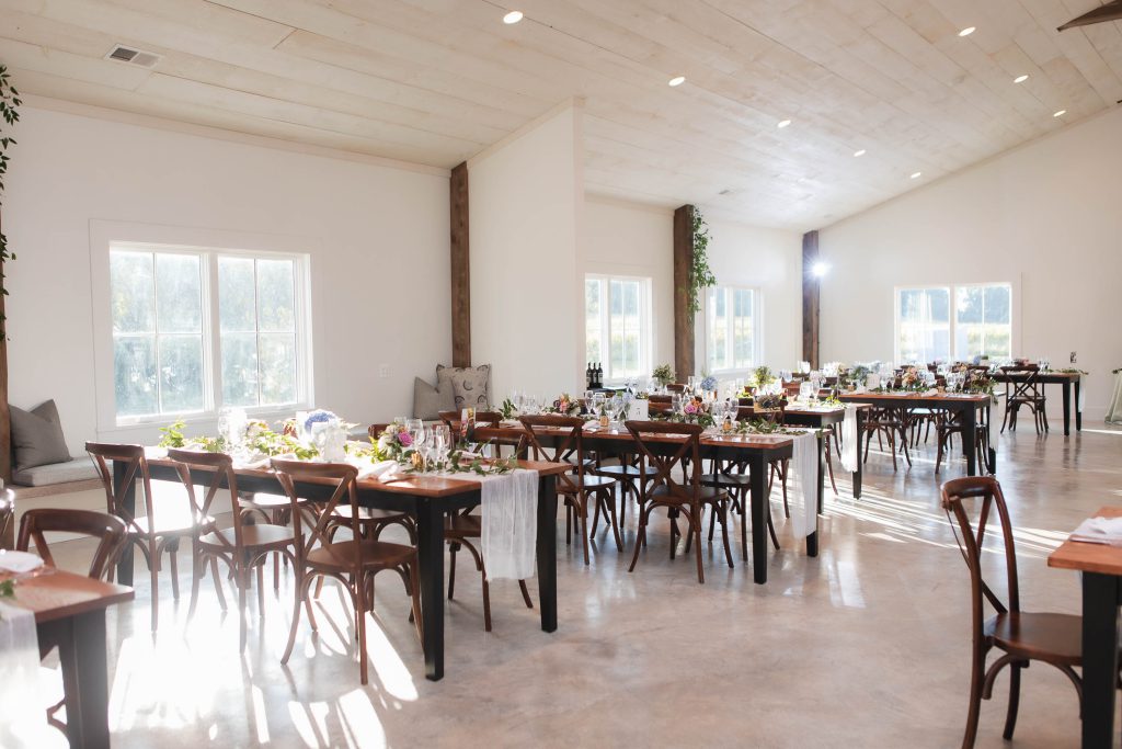 A detailed wedding reception set up at Fleetwood Farm Winery, complete with tables and chairs.