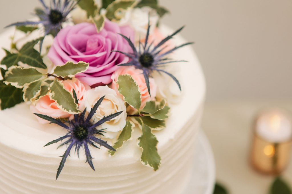 A beautiful wedding cake adorned with delicate pink and purple flowers.