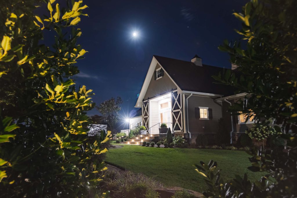 The Fleetwood Farm Winery is beautifully illuminated at night, creating a captivating ambiance for a wedding celebration under the full moon.