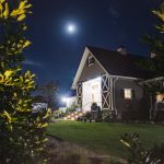 The Fleetwood Farm Winery is beautifully illuminated at night, creating a captivating ambiance for a wedding celebration under the full moon.