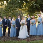 A group of bridesmaids and groomsmen posing in front of a tree at Fleetwood Farm Winery for their wedding portrait.