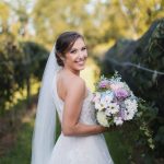 A bride holding a wedding bouquet in a vineyard at Fleetwood Farm Winery.