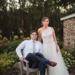 A bride and groom sitting on a chair in the garden at Fleetwood Farm Winery, captured in a beautiful portrait.