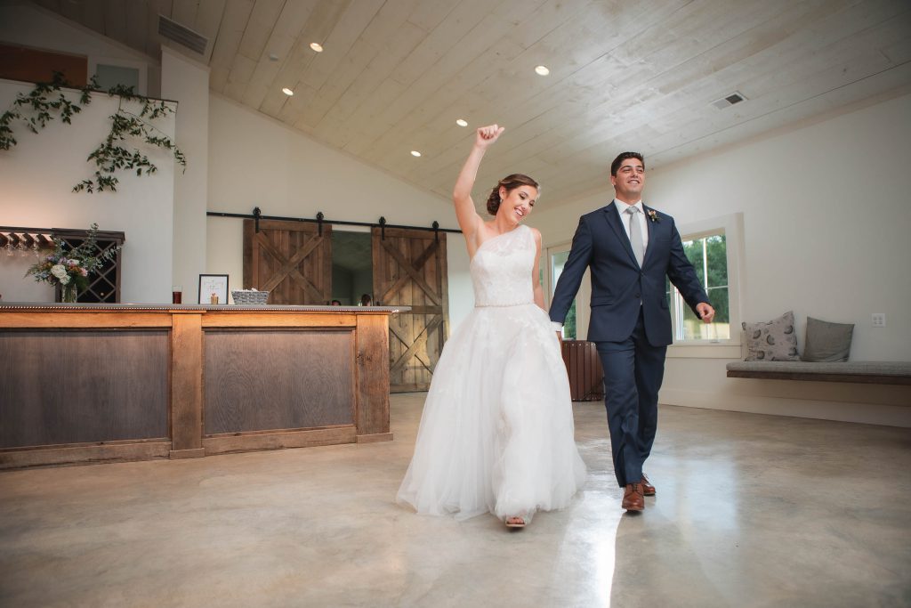 A bride and groom walking through a wedding reception at Fleetwood Farm Winery.
