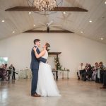 A bride and groom sharing their first dance at a wedding reception in a barn at Fleetwood Farm Winery.