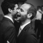 Two men sharing a kiss at a wedding reception at Fleetwood Farm Winery.