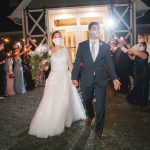 A bride and groom walk out of Fleetwood Farm Winery with sparklers, ready to celebrate their wedding reception.