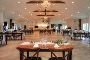 Event vendor Dragonfly Events and Design offers a wedding reception set up with tables and chairs.