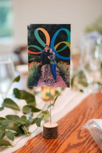 A photo of a couple at an event vendor's wooden table.
