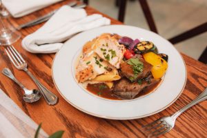 A plate with meat and vegetables at a Main Event Catering event.