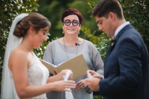 A bride and groom reading their wedding vows with event vendor.