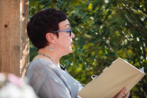 A woman vendor in glasses reading a book.