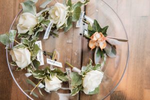A glass plate with colorful flowers and event vendor tags.