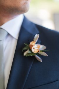 A man in a suit with a Pink Poppy on his lapel.