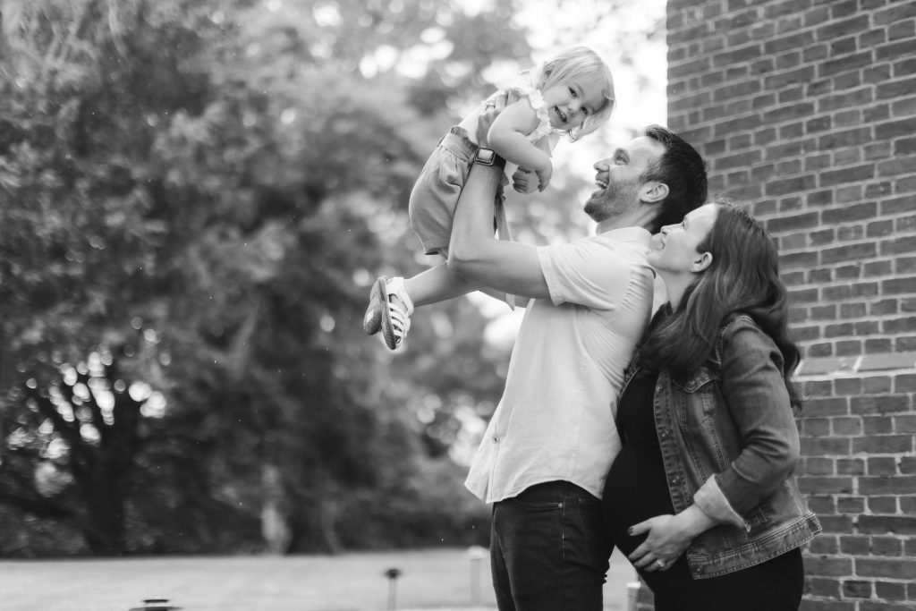 Black and white family portrait in front of a brick building.
