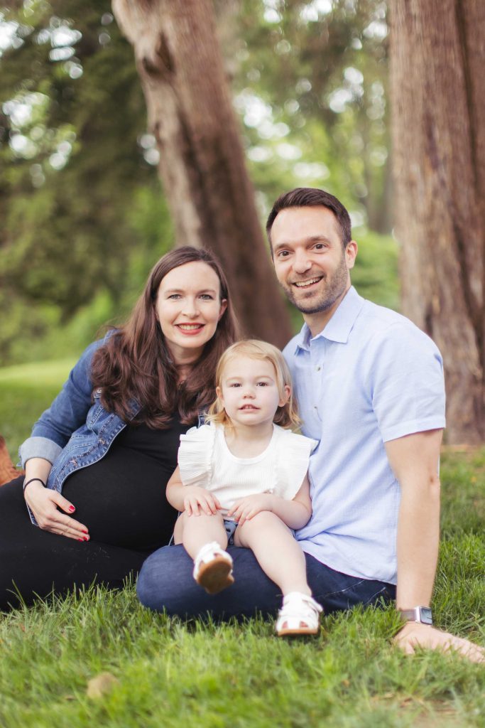 A family sits on the grass for portraits.