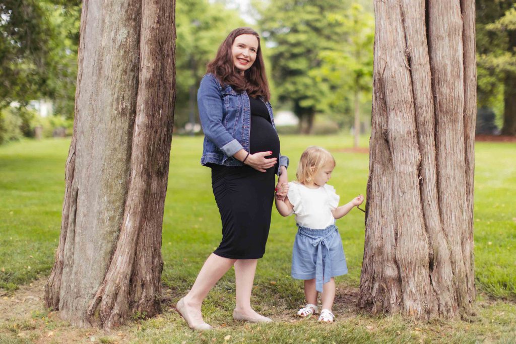 A family standing next to trees in a park.
