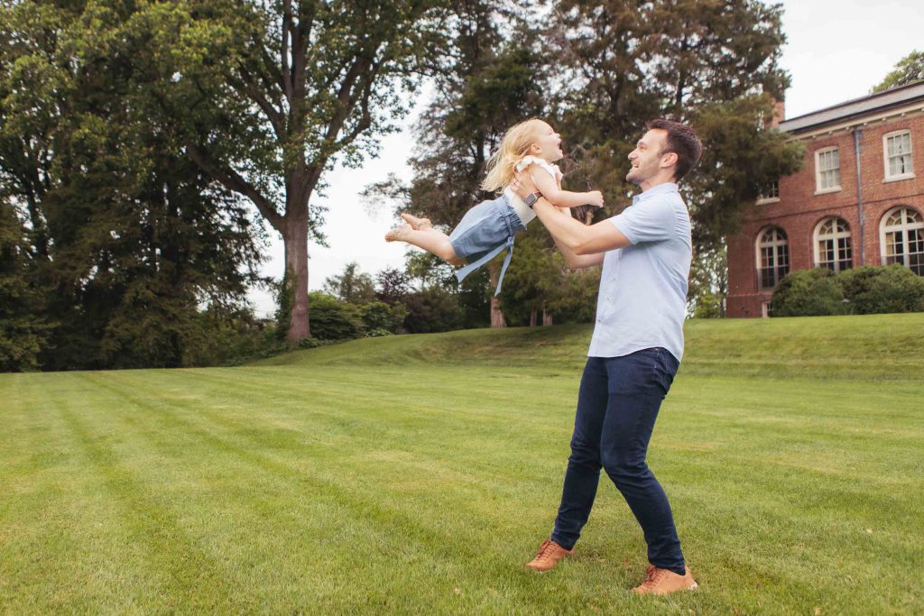 A family playing in front of a Bel Air Mansion.
