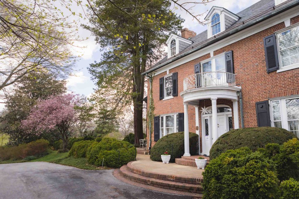 A brick home with a large front porch perfect for wedding ceremonies.
