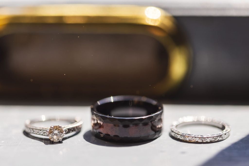 Wedding rings with intricate details displayed on a table.
